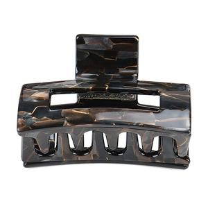 Macro detail of amber patterned hair claw clip with a hollow geometric rectangle design