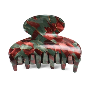 Detail of medium acetate hair claw clip with vintage red, green, and gold mosaic pattern