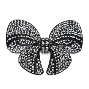 Macro shot of large black bow hair clip with sparkling rhinestones on spring clasp
