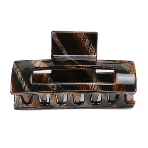 Detail of large acetate hair claw clip featuring a vintage tortoiseshell pattern and glossy finish