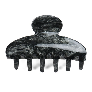 Détail d'une grande pince à cheveux en acétate avec texture marbrée noire et grise