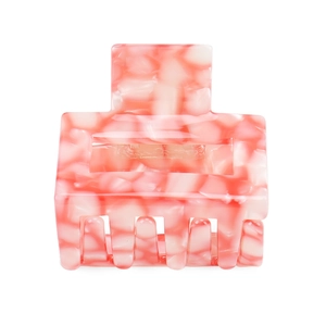 Detail of square hair claw clip with pink marble acetic acid texture on white background
