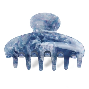 Vue détaillée d'une grande pince à cheveux en acétate à motif marbre bleu et blanc