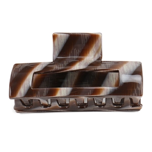 Macro detail of large square acetate hair claw clip with vintage marble texture