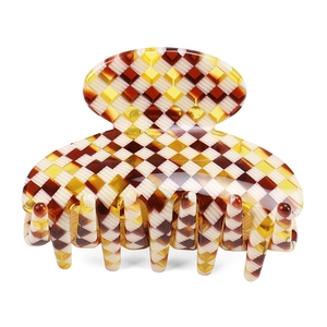 Detail of medium acetate hair claw clip featuring brown and beige checkerboard pattern