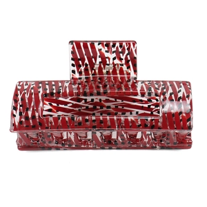 Macro detail of large acetate claw clip with red white stripes and black artistic spots