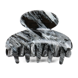Close-up of black and white marbled acetate hair claw clip with glossy mirror finish