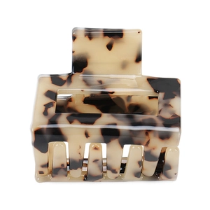 Detailed close-up of a tortoiseshell acetate rectangular hair claw clip with smooth teeth
