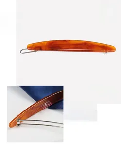 Détail de la pince à cheveux en acétate ambré de 7,2 cm avec texture et ressort métallique