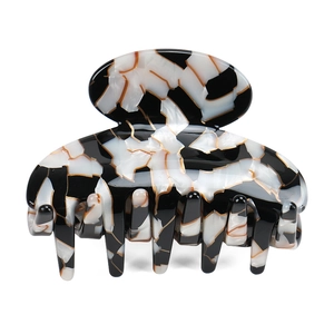 Detailed view of large marble texture hair claw clip made of acetic acid plate with gold lines