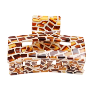 Detail of a geometric amber tortoiseshell acetic hair claw with a hollow design