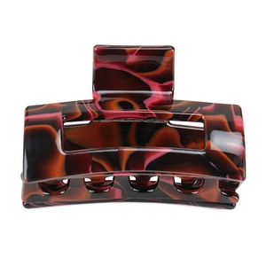 Detailed close-up of a rectangular hair claw clip with brown and amber acetate tortoiseshell pattern