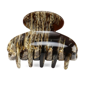 Detail of tortoise shell acetate hair claw clip with glossy leopard pattern and sturdy teeth
