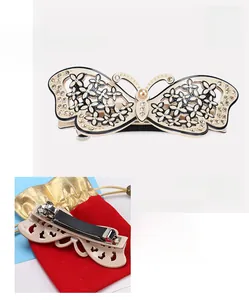 Detail showing acetate butterfly hair clip with rhinestones and pearls on a metal spring clip