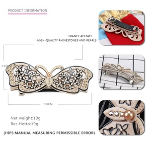 Bow-shaped acetate hair clip with Czech rhinestones and pearl detail shown in 9.8cm size