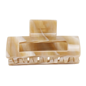 Detail of large square acetate hair claw clip with beige marble texture and strong teeth