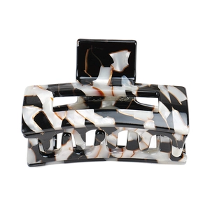 Macro view of geometric hollow acetate hair claw with black and white marble pattern
