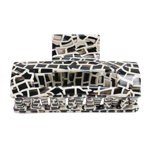 Detailed view of large square acetate hair claw with black and white mosaic pattern