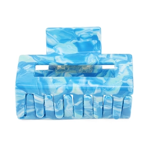 Macro detail of blue marble acetate hair claw with rectangular hollow frame and metal spring