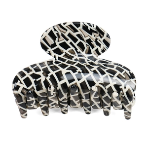 Detail of medium acetate hair claw clip with black, white, and grey geometric marble pattern