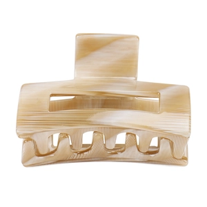 Detail view of cream acetate hair claw clip with anti-slip stripes and marble texture