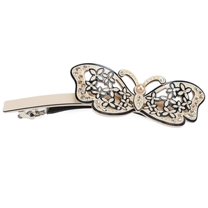 Detailed close-up of a beige acetate butterfly hair clip with rhinestones and pearl