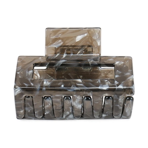 Macro shot of rectangular acetate hair claw clip with grey marble texture and gloss