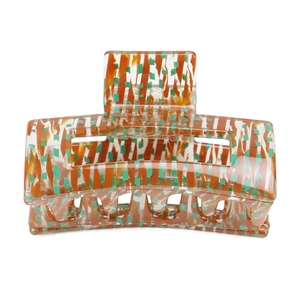 Detail of hollow geometric hair claw made of tortoise acetate with orange and green spots