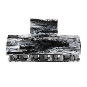 Detailed view of large square acetate hair claw with artistic black and white marble pattern