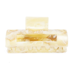 Detail of large acetate hair claw clip featuring creamy yellow marble pattern and smooth texture