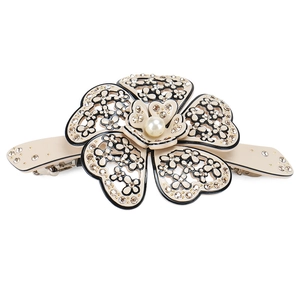 Detail view of camellia hair clip with champagne rhinestones and a central pearl