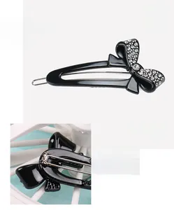 Detail of a black acetate bow hair clip with rhinestones and metal spring clip back