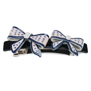 Detailed view of navy blue and pink bow hair clip with sparkling blue rhinestones