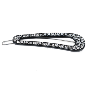 Close-up of a drop-shaped black hair clip with sparkling rhinestones on a metal base