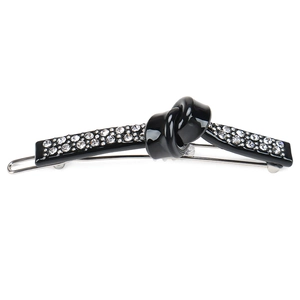 Detail of elegant black resin hair clip with knotted design and sparkling rhinestones