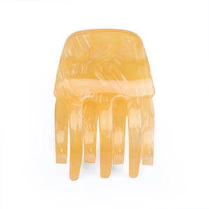Close-up of amber yellow acrylic hair claw with elegant marble stripe texture