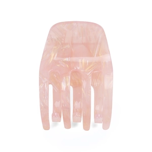 Close-up of pink translucent acrylic claw clip with gold marble texture and fine teeth