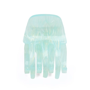 Detail shot of a mint green acrylic hair claw clip with a marbled translucent texture