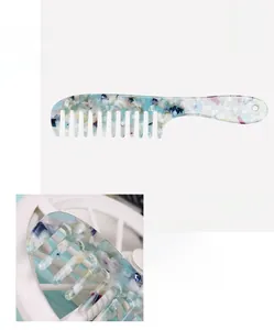 Detail of wide-tooth France Acetate hair comb with blue and white marble pattern texture