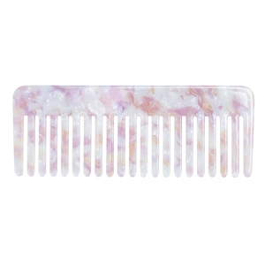Detailed close-up of a pink marble acetate hair comb with smooth wide teeth