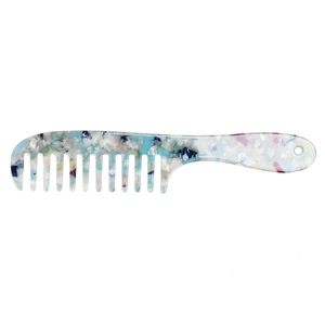 Macro detail of wide-tooth acetate hair comb with blue marble floral pattern texture