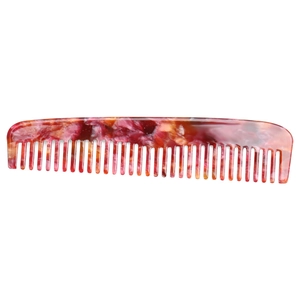 Detailed macro view of the marble texture on a red and pink antistatic acetate hair comb