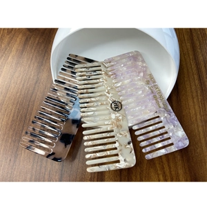 Three wide-tooth hair combs in acetate tortoiseshell, beige and lilac marble textures