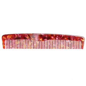 Close-up of hair comb showing vibrant orange marble texture and dense bristles