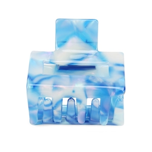Close-up of acetic acid geometric hair claw with blue and white marble texture