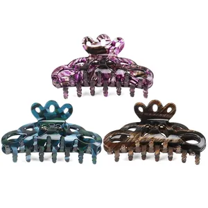 Three-piece acetate hair claw clips set in purple marble, teal grid, and wood grain patterns