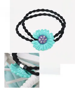 Dettaglio dell'elastico per capelli con fiore in acetato verde da 2,3 cm e strass lucidi