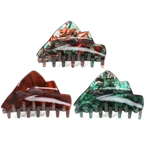 Three acetate hair claws in amber, marble green, and colorful oil painting textures