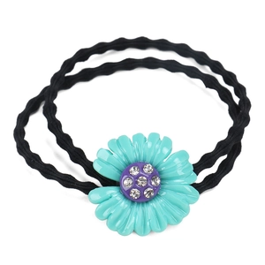 Dettaglio dell'elastico per capelli a margherita blu con strass e doppia fascia nera
