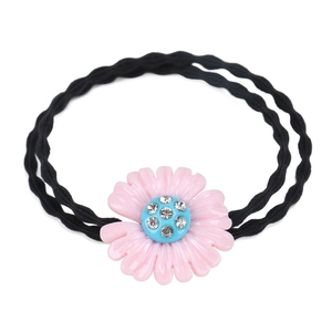 Dettaglio dell'elastico per capelli con fiore in resina rosa, centro blu e strass